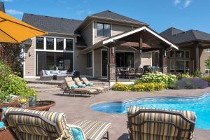 luxury home backyard with pool and lawn chairs