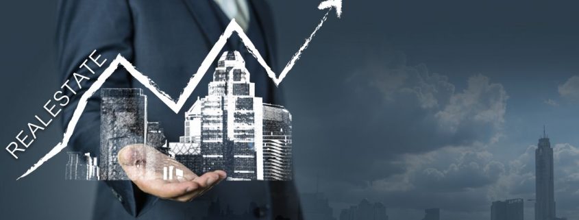 person holding a building with an arrow pointing up showing real estate trends rising