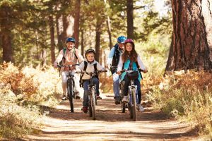 family of 4 biking on a trail