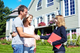 Kelowna real estate agent greeting couple outside Kelowna home