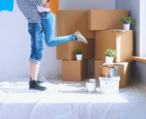 two young adults standing in front of moving boxes in their first Kelowna home