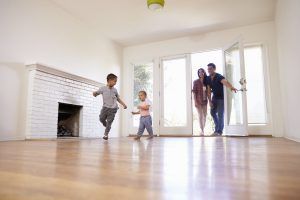 family standing in living room of their new home