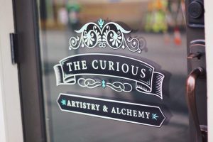 sign on door of curious cafe located in downtown Kelowna