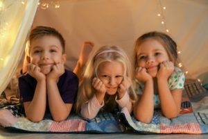 three children sitting in indoor movie theatre 