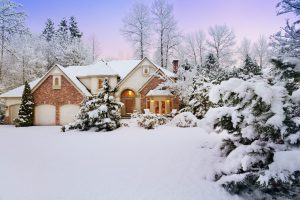 Kelowna home with snow over front lawn and home