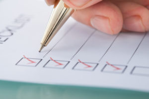 person writing a checklist for home