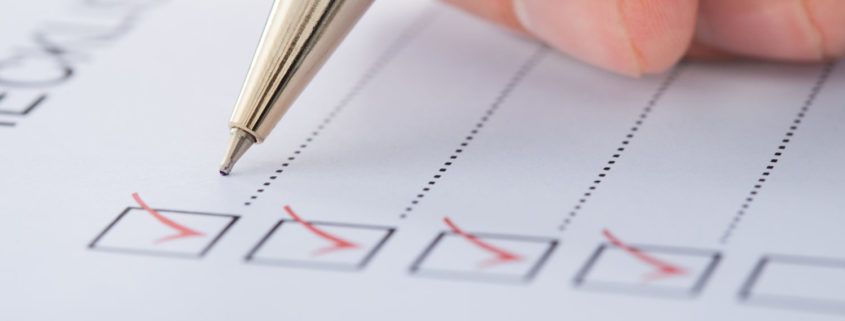 person writing a checklist for home