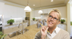 lady standing in kitchen thinking of staging ideas