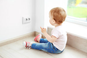 toddler sitting in front of electrical outlet in Kelowna real estate