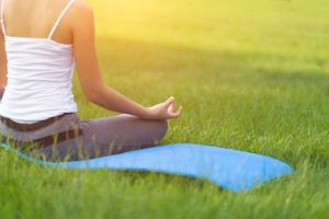 lady sitting on lawn doing yoga