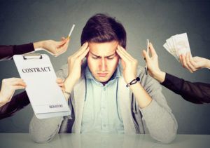 man sitting on chair with a contract being presented to him