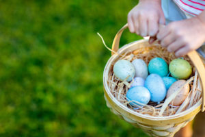 girl holding basket full of Easter eggs