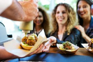 food truck serving three ladies sandwiches