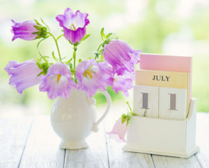 July calendar with flowers beside