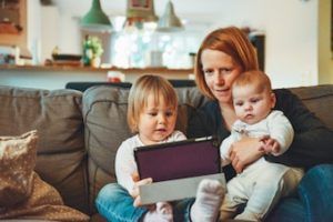 mother and children sitting on couch in living room