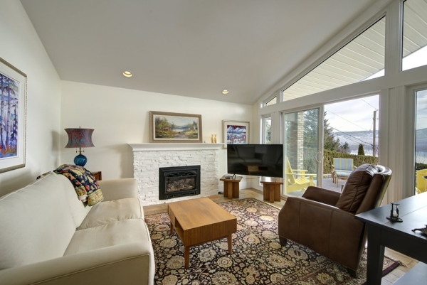 Cozy family room with a fireplace and large windows with a sliding door leading to the large patio in 2650 Lakeview