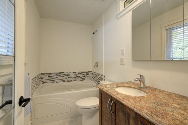 Primary Ensuite bathroom with soaker tub, show combo and spacious single sink vanity in 2650 Lakeview